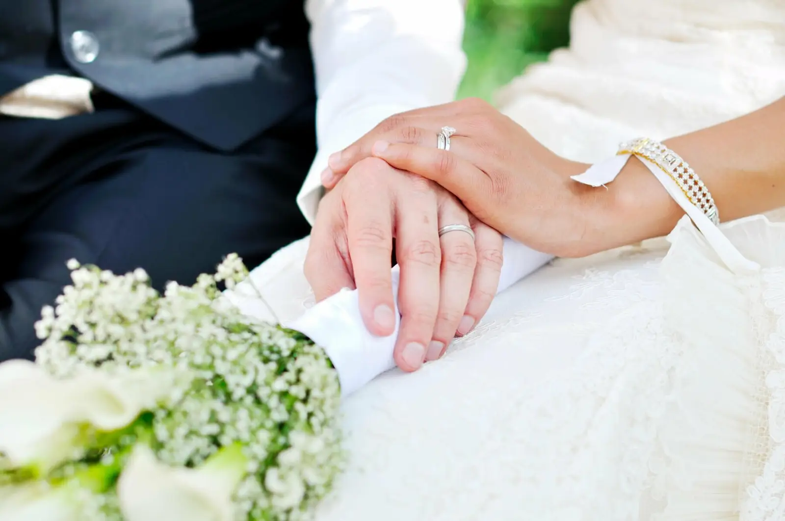 Demande en mariage avec deux mains l’une sur l’autre et alliances or