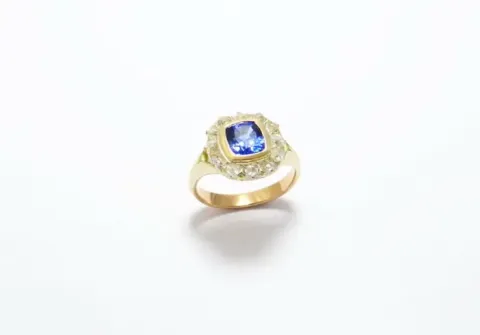 Marquise-shaped ring with a cushion-cut Ceylon sapphire surrounded by diamonds