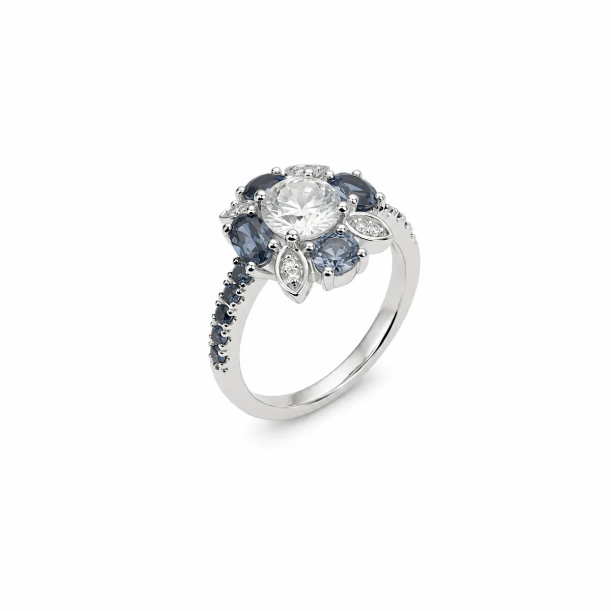 Bague en forme de fleur en or blanc 18 carats ornée d\'un diamant central, de saphirs bleus et de diamants, bijou de haute joaillerie élégant et intemporel.
