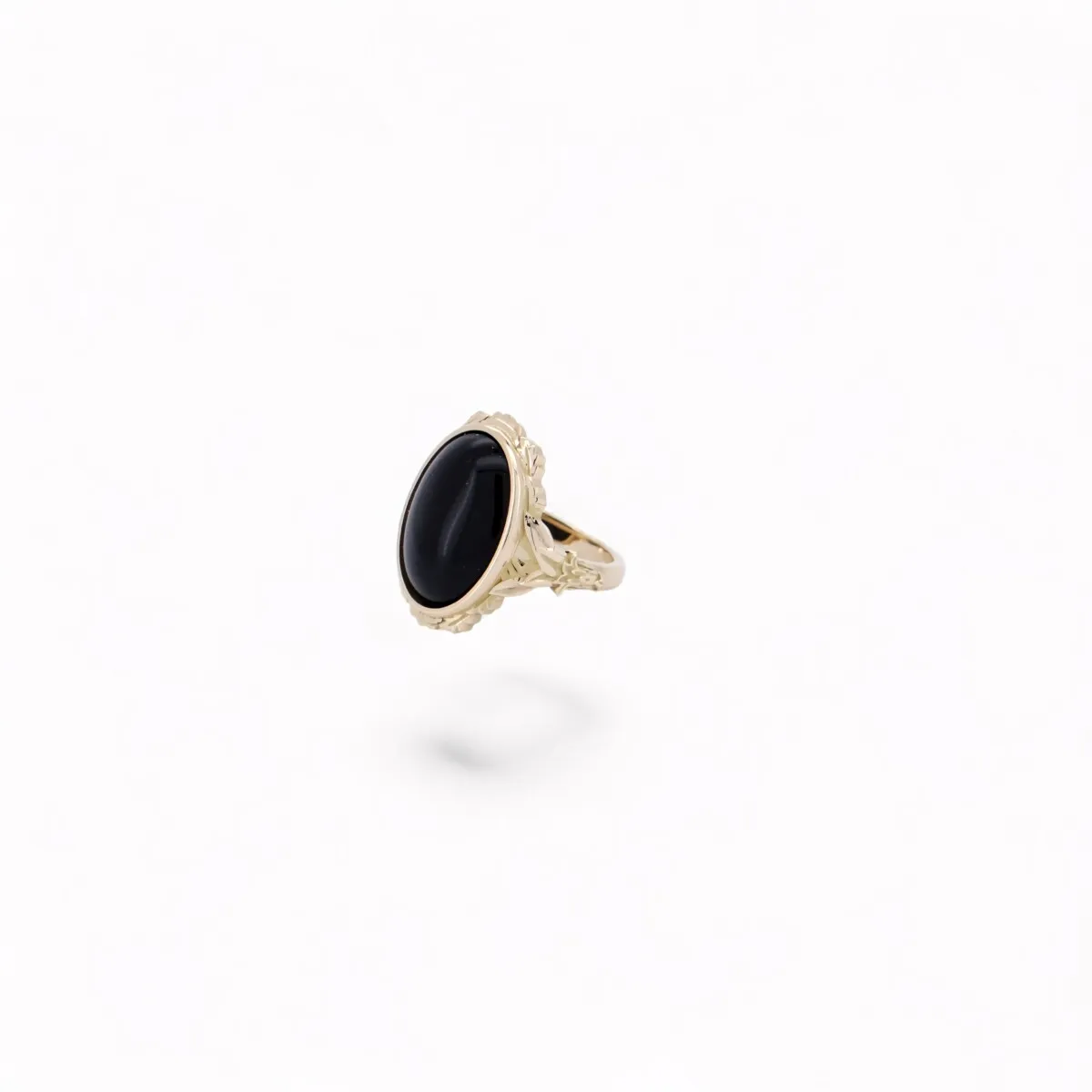 Bague chevalière en or jaune 18 carats ornée d\'un onyx noir en cabochon, bijou de haute joaillerie pour homme au design raffiné.