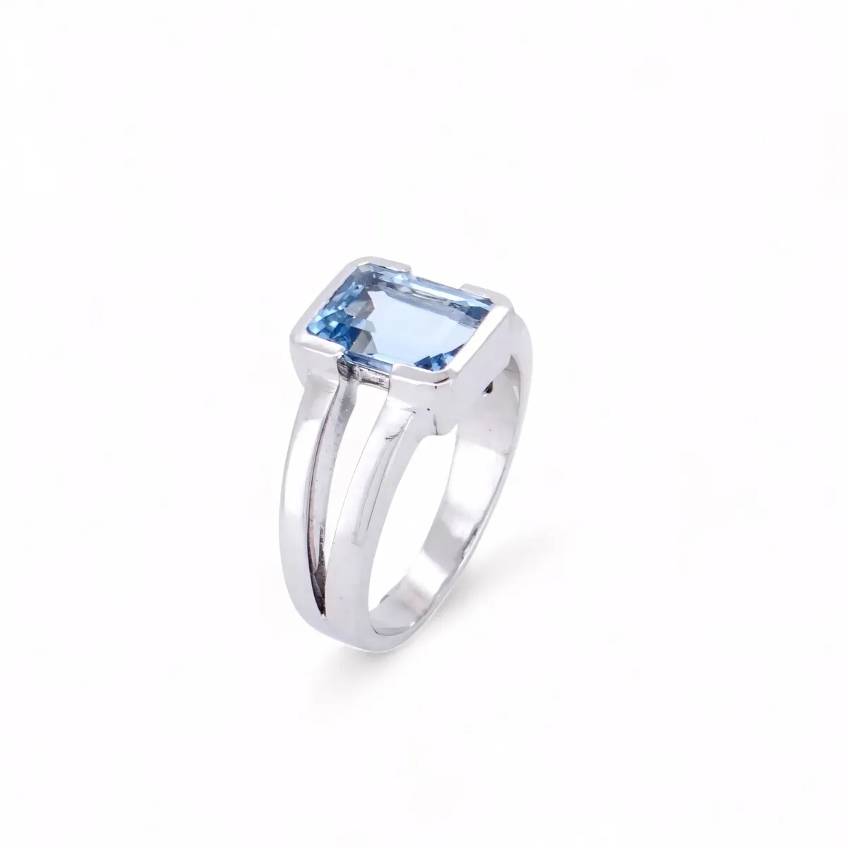 Bague solitaire en or blanc 18 carats ornée d\'une aigue-marine naturelle taille émeraude, bijou de haute joaillerie élégant et intemporel.