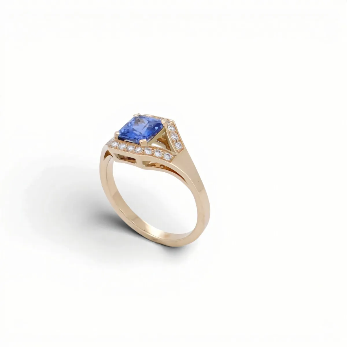 Bague ancienne géométrique en or rose ornée d\'un saphir bleu taille rectangulaire pavé de diamants