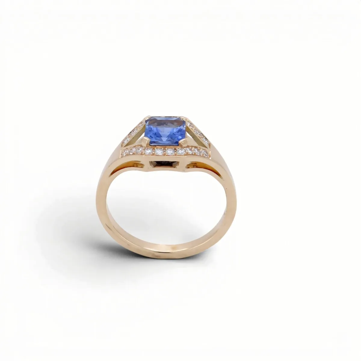 Bague de fiançailles en or rose, saphir bleu rectangulaire entouré d\'un pavage de diamants, style ancien