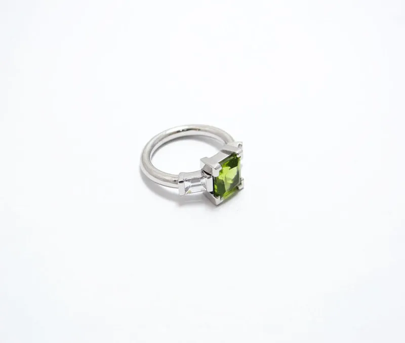 bague en or blanc palladié avec deux diamants baguettes en serti semi clos et un peridot en serti griffe de taille carré