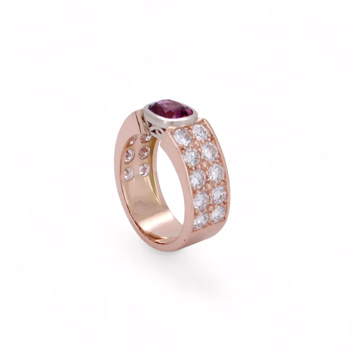 Bague élégante en or rose ornée d’une pierre rouge profonde et d’un pavage de diamants latéraux