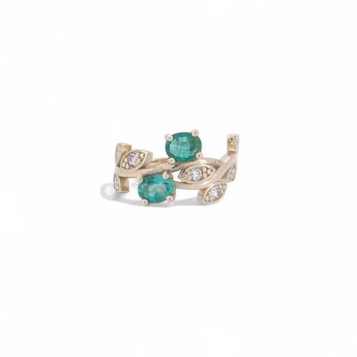 Bague en or jaune avec trois pierres vertes type émeraude et petits diamants sertis sur un motif ondulé