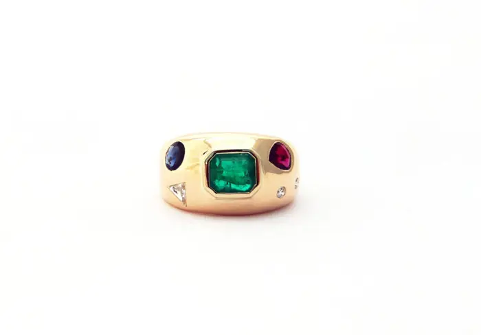 bague jonc en or jaune 18 carats serti d'une émeraude un rubis poire un diamant triangle un saphir rond