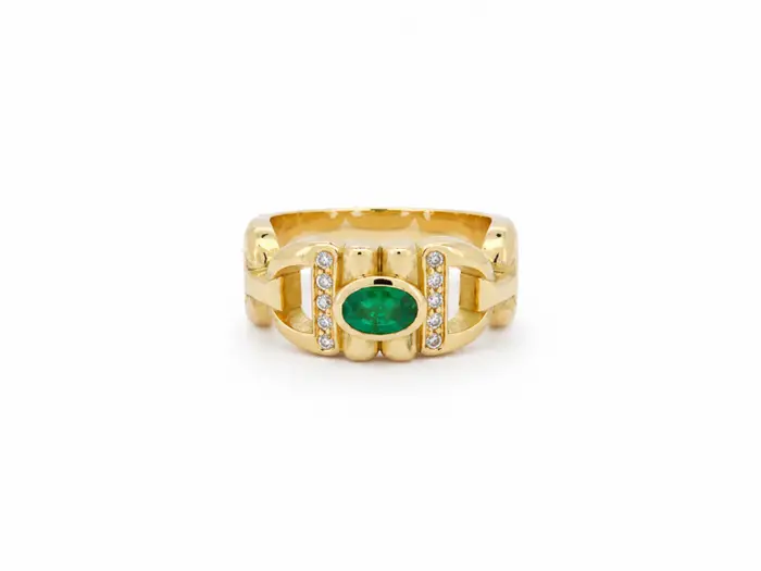 Bague or jaune 18 carats ornée d'une émeraude ovale et d'un pavage de diamants, bijou de haute joaillerie au style moderne et raffiné.