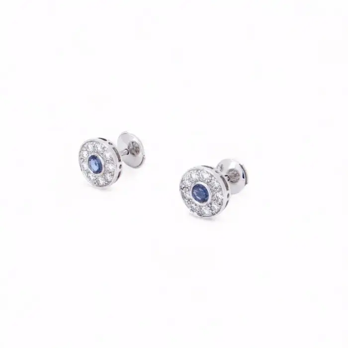 Boucles d'oreilles puces en or blanc 18 carats serties de saphirs de Ceylan entourés d'un halo de diamants, bijou élégant et intemporel.