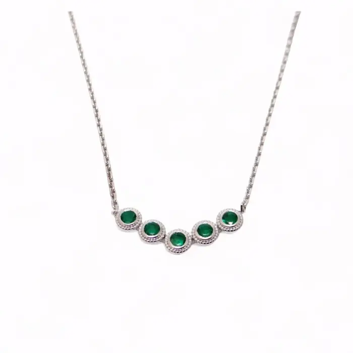 Collier en or blanc 18 carats avec cinq émeraudes rondes naturelles, création artisanale signée Maupas Sehikyan, au style intemporel.