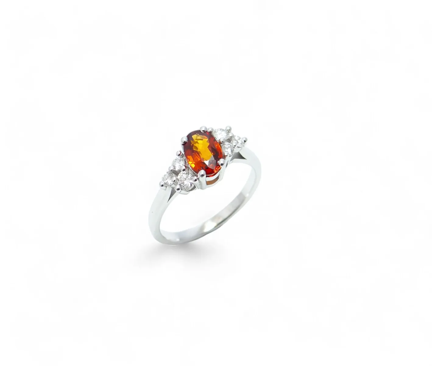 bague grenat spessartite ovale au centre serti sur quatre griffes avec 6 diamants sur les cotés serti griffes monture or blanc
