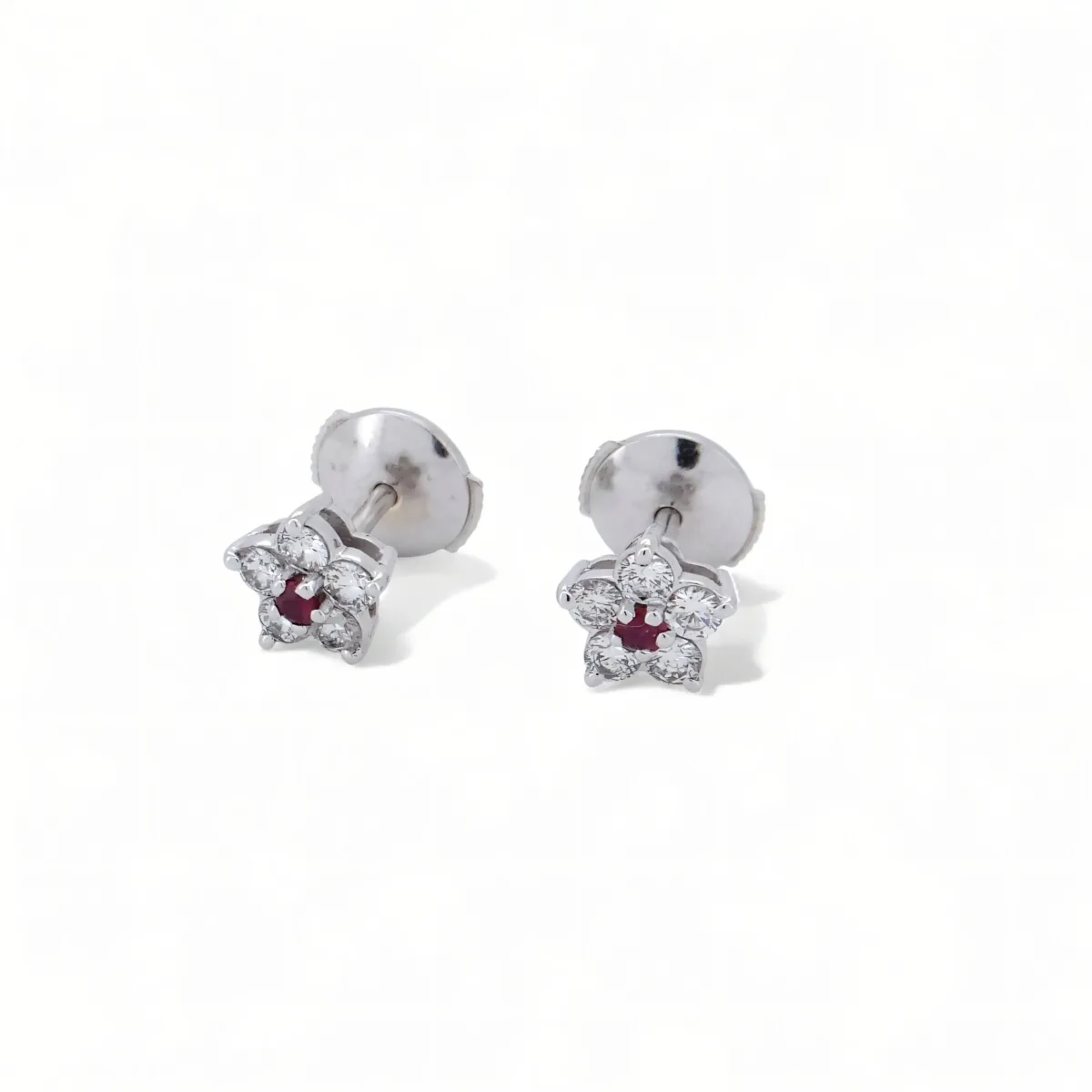 Paire de puces d’oreilles fleur en or blanc, diamants ronds et rubis central.