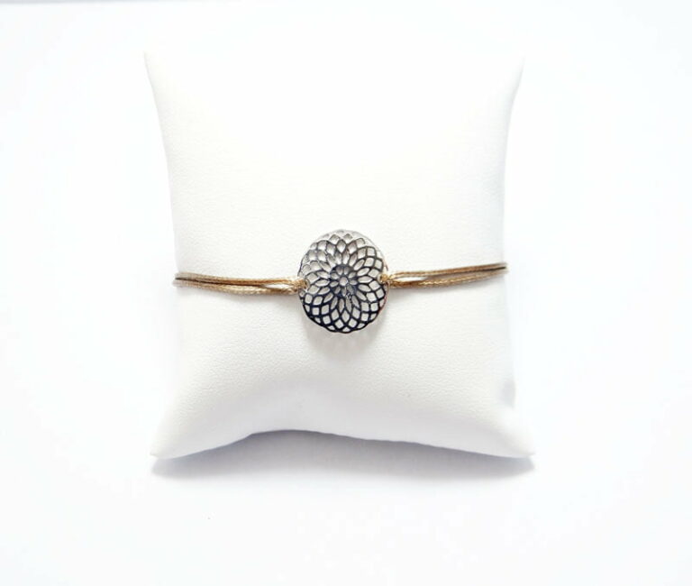 Bracelet rosace en or 18 carats et cordon polyester ciré.