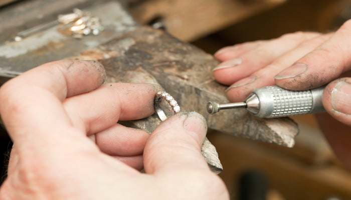 bijoutier répare une alliance en or diamant