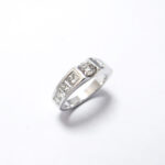 bague en or blanc 18 carats au centre un diamant rond et sur les cotés des diamants carré