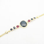 bracelet articulé avec charnières serti de saphir cabochon et rubis facetté monture en or jaune 18 carats