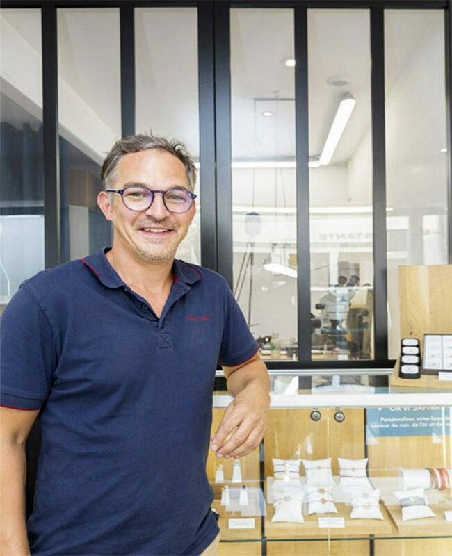 le joaillier qui pose devant sa vitrine et son ateleier boutique située a saint sébastien sur loire