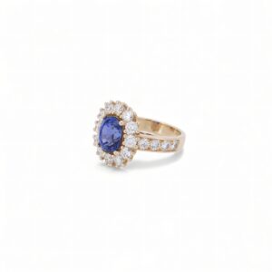 Monture en or jaune 18 carats sublimée par un saphir de Ceylan taille ovale de 3 carats et un halo de diamants ronds – pièce unique de haute joaillerie.