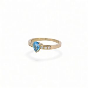 bague en or jaune 18 carats avec au centre une topaze bleu en forme de poire et sur le corps de bague 6 diamants serti en grains
